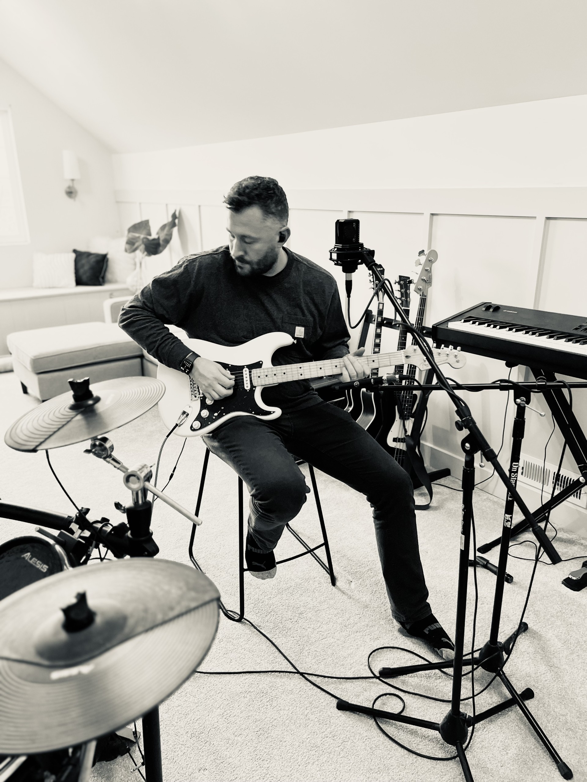 Riley Wilkinson performing an acoustic guitar part during a recording session
